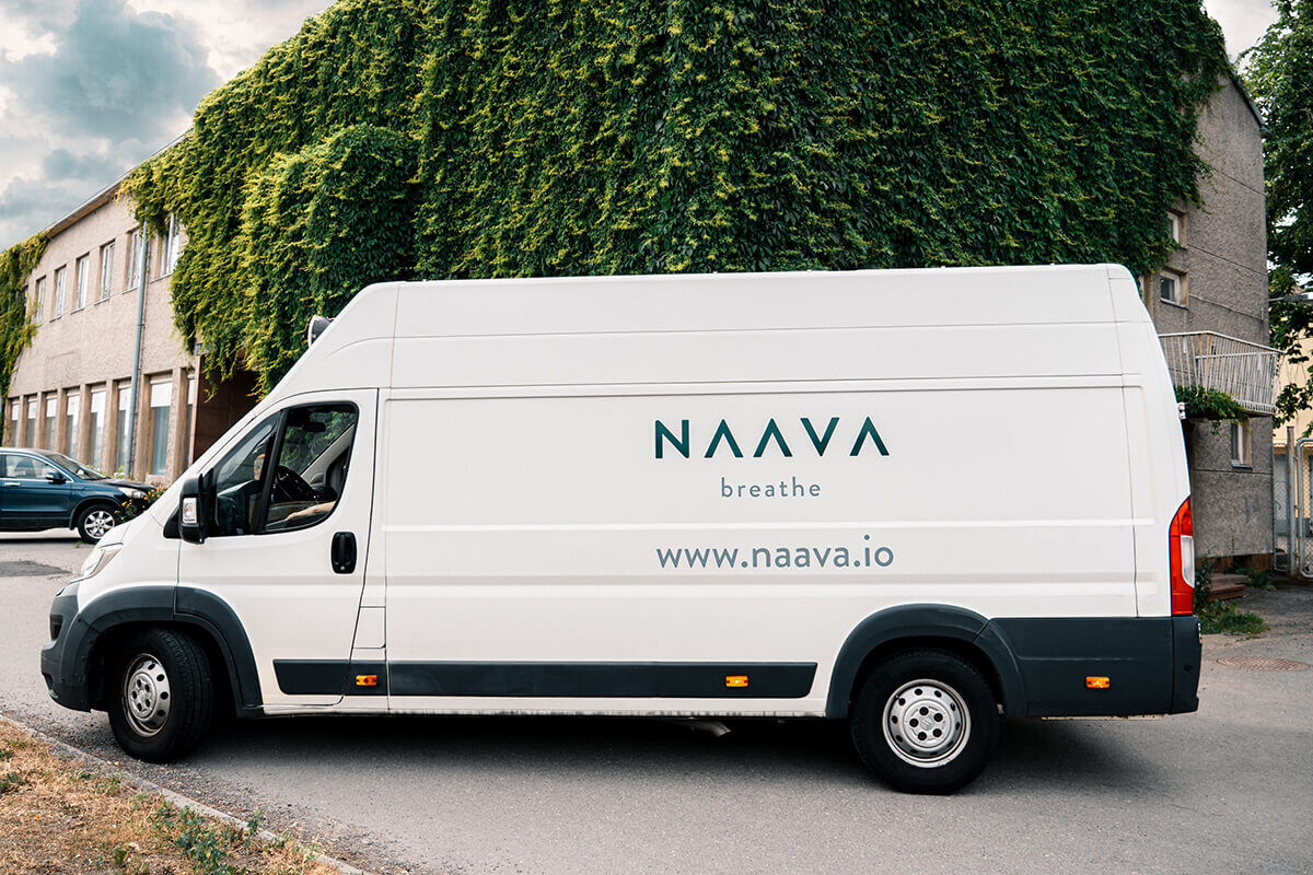 Naavan viherhuollon pakettiauto suomessa ulkona köynnäksen peittämän talon edessä Naavan viherhuollon pakettiauto suomessa ulkona köynnäksen peittämän talon edessä